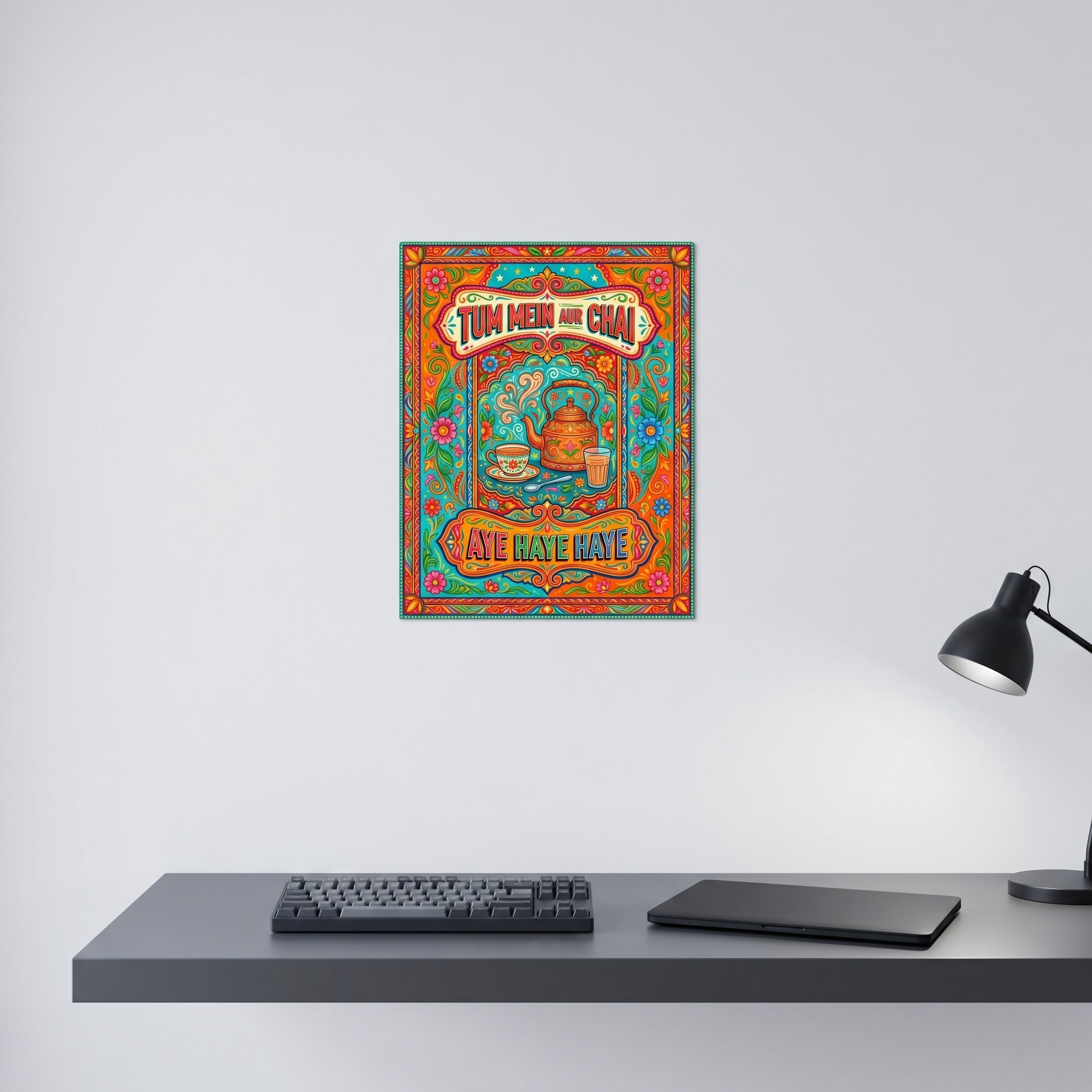 Funny Desi tea culture art print displayed neatly on a white wall behind a modern minimalist computer workspace with a desk lamp.