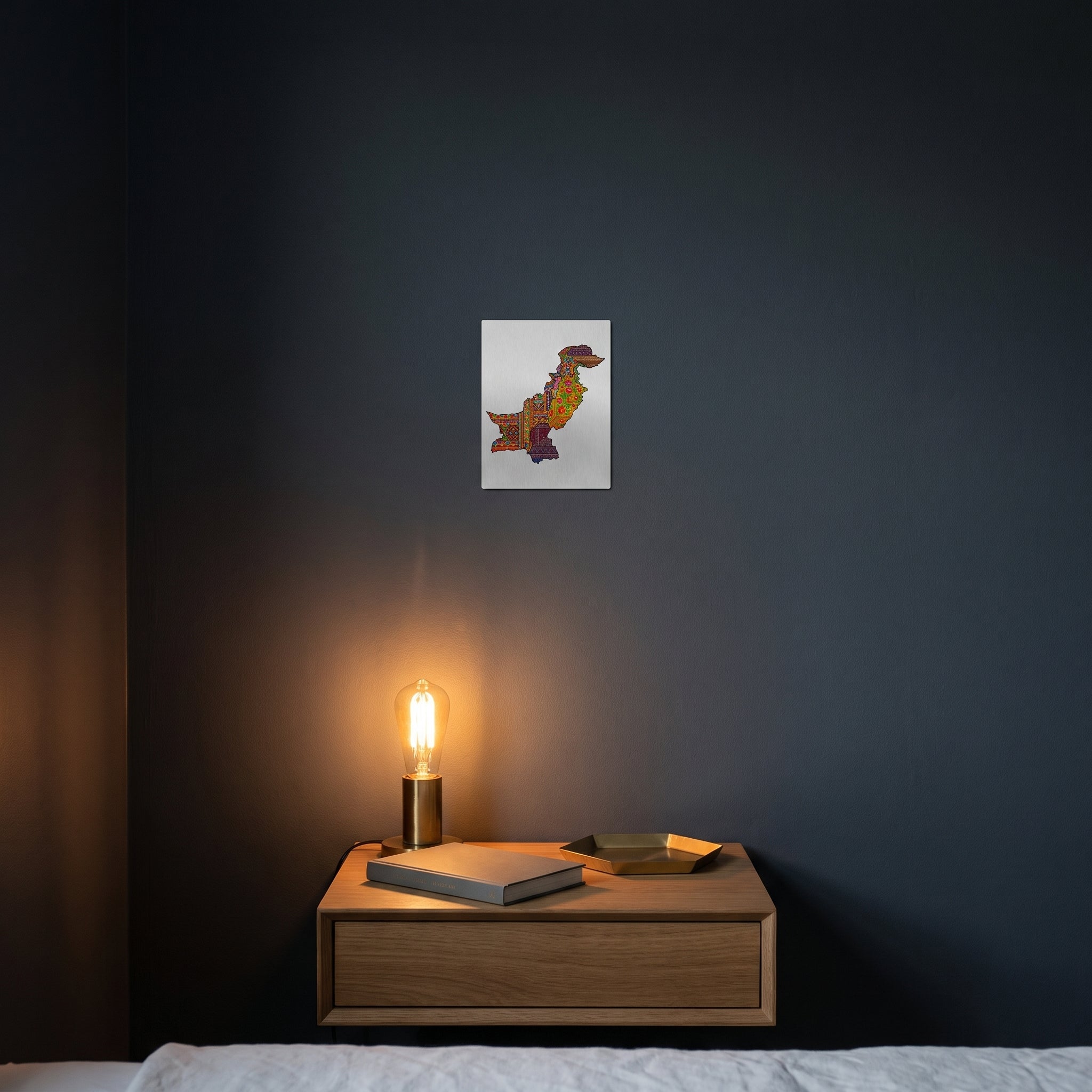 Modern cultural pattern map of Pakistan print displayed on a dark charcoal grey accent wall over a sleek wooden console floating cabinet.