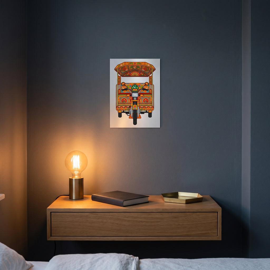 Pakistani orange motorcycle rickshaw art metal poster styled on a contemporary bedroom nightstand catching warm ambient light from a lamp.
