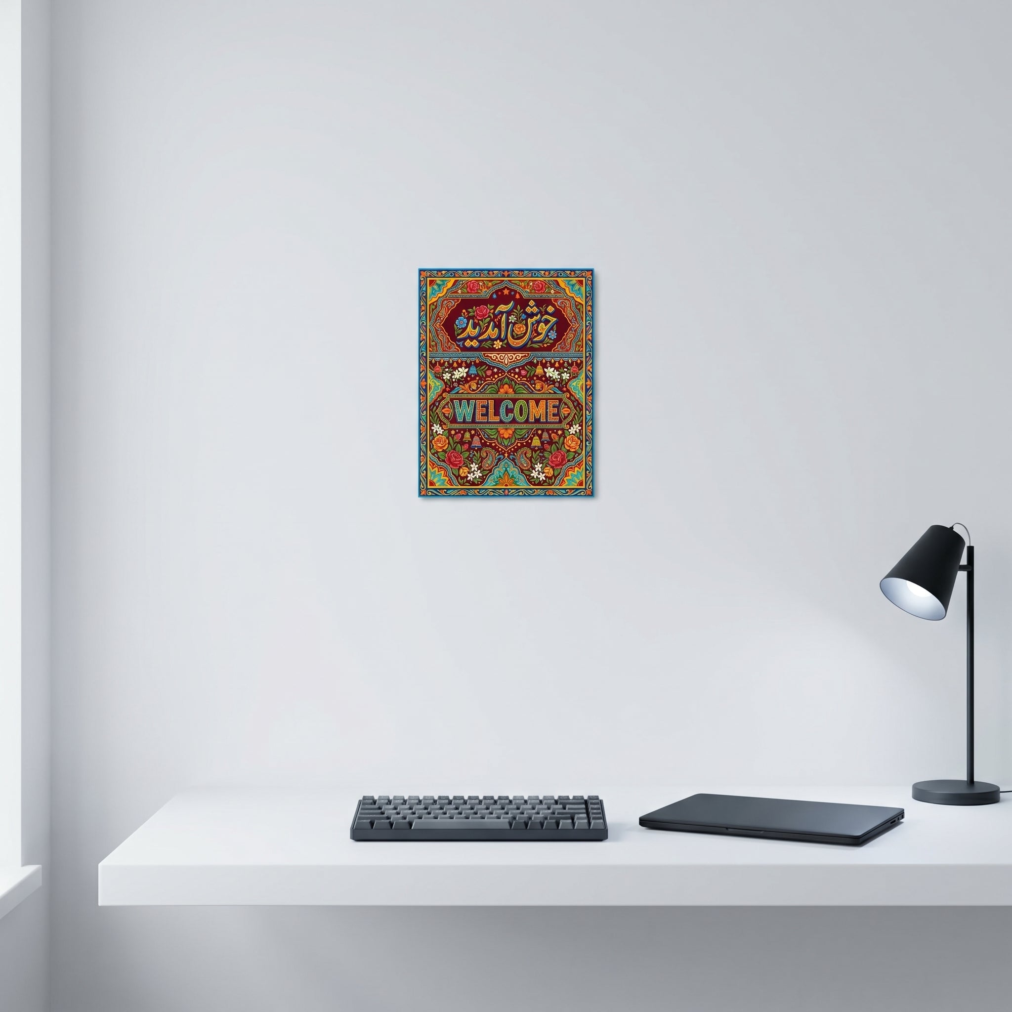 "Traditional Pakistani truck art welcome poster displayed neatly on a white wall behind a modern minimalist computer workspace."
