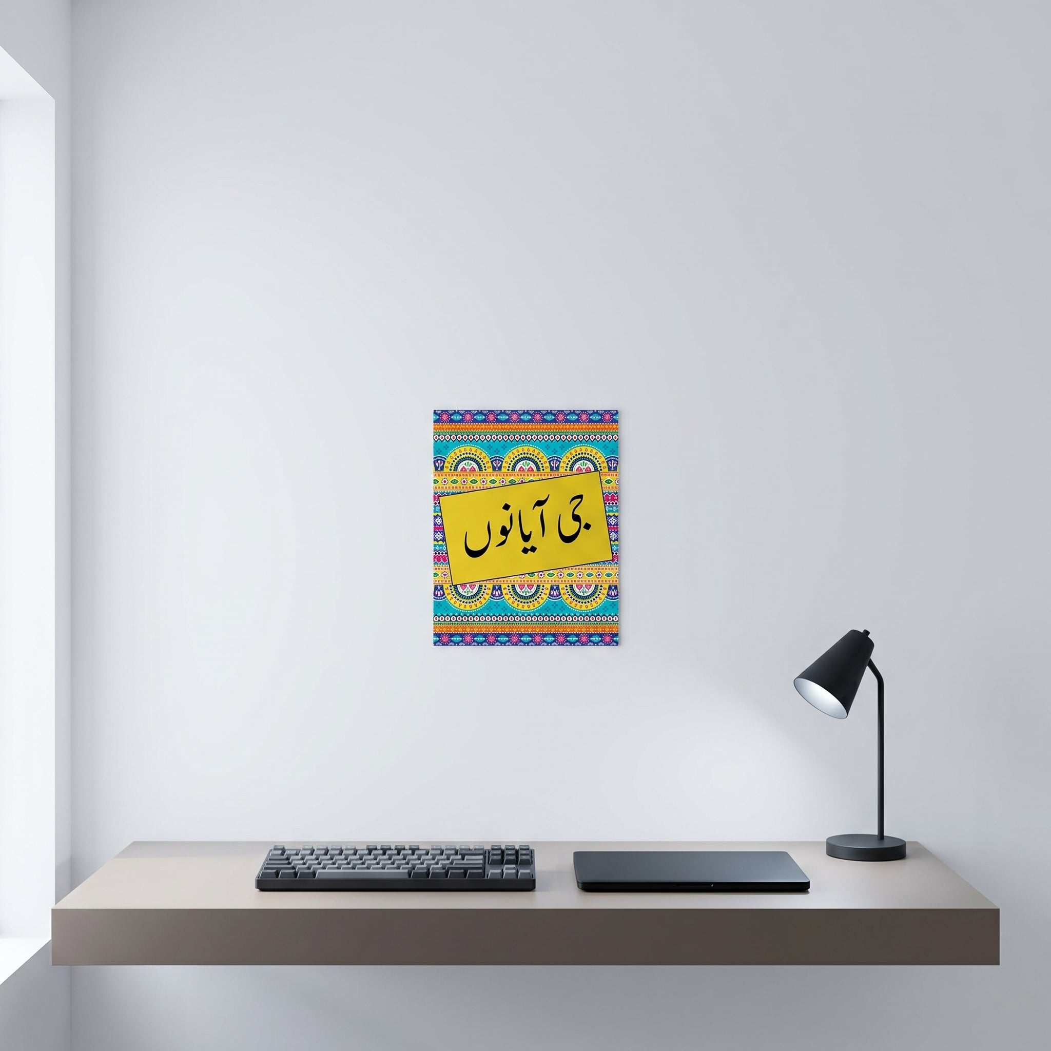 Traditional Punjabi typography greeting wall art print hanging neatly on a white wall above a minimalist home office computer workspace.