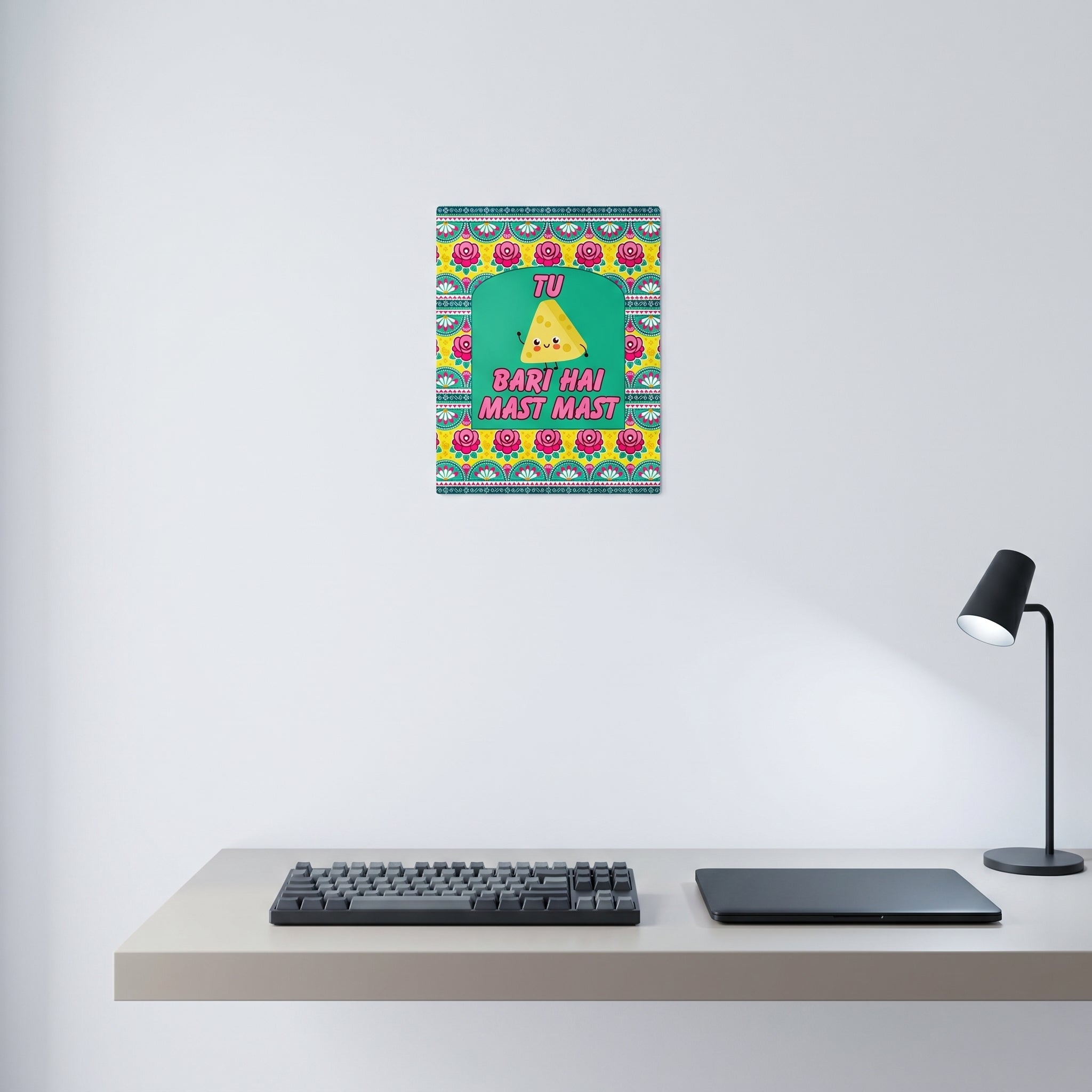 Traditional style South Asian pop art poster displayed on a white wall behind a minimalist home office desk setup.
