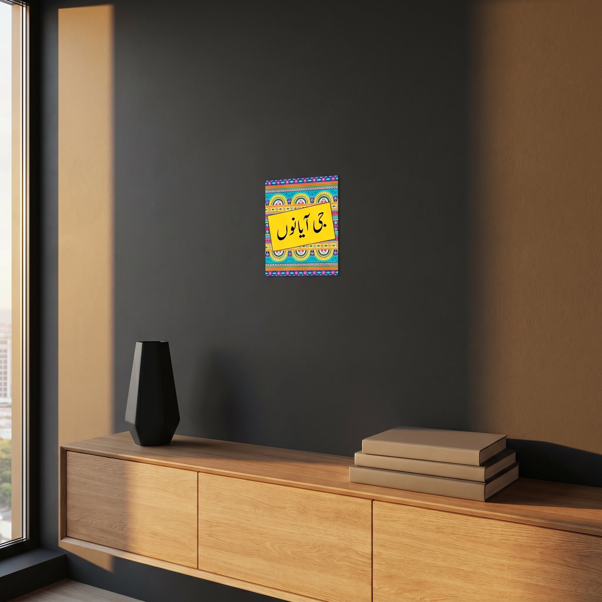 Vibrant Urdu and Punjabi slogan culture poster styled beautifully on a dark grey accent wall over a modern wooden sideboard cabinet.