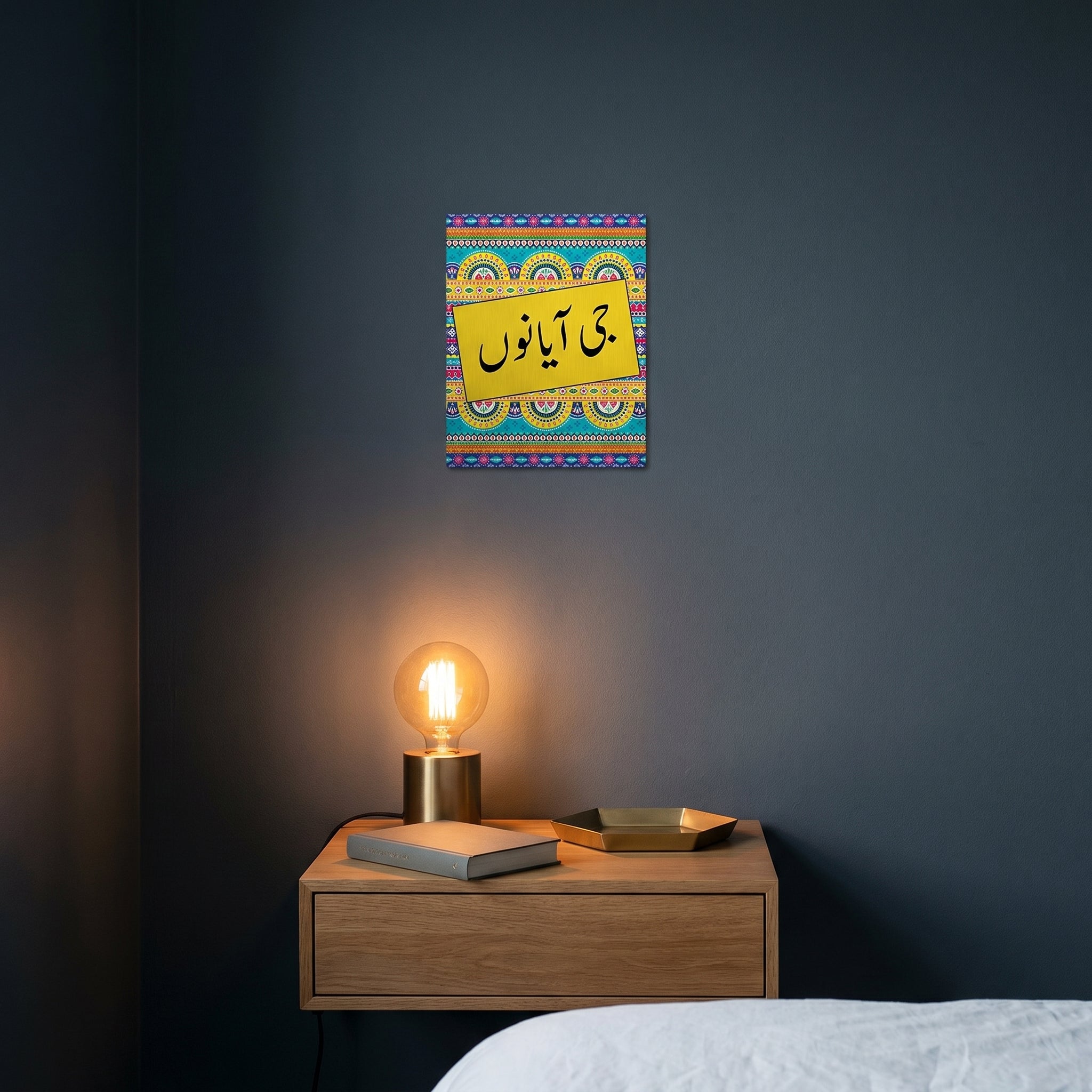 Vibrant yellow and blue truck art room decor print hanging under warm ambient lamp light above a contemporary bedroom nightstand.