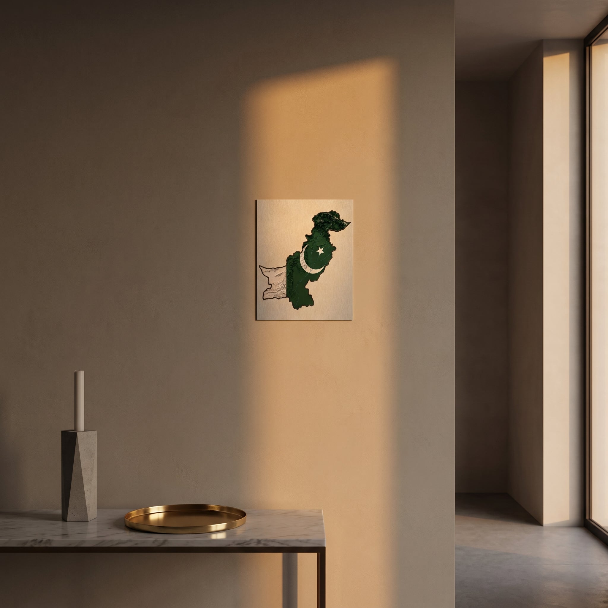 
Sleek topographic Pakistan flag heritage metal print catching warm afternoon window sunlight on a textured plaster wall above a table.